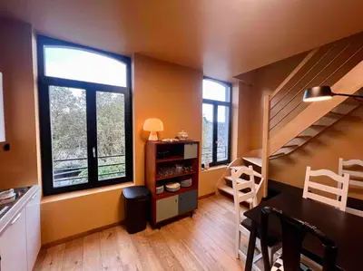 a kitchen with a staircase and a table and some windows at Le rétro chic - Grand Duplex pour 6 dans le centre in Liège