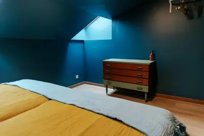 a blue bedroom with a bed and a dresser at Le rétro chic - Grand Duplex pour 6 dans le centre in Liège