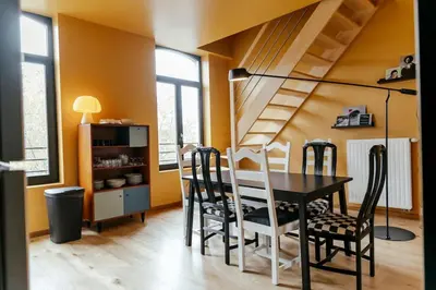 a dining room with a black table and chairs at Le rétro chic - Grand Duplex pour 6 dans le centre in Liège