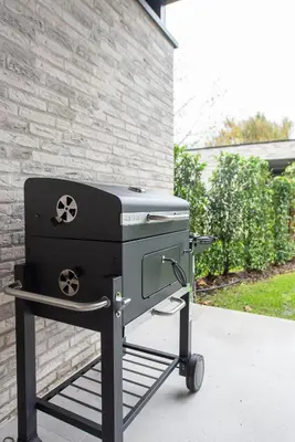 a grill on a cart in front of a house at NIEUW - De Grenspaal OOST 7P - 3SLPK - SAUNA - LAADPAAL in Riemst