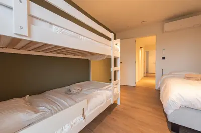 two bunk beds in a room with a hallway at NIEUW - De Grenspaal OOST 7P - 3SLPK - SAUNA - LAADPAAL in Riemst