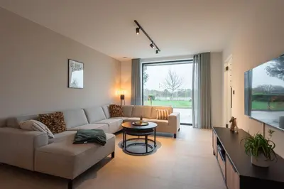 a living room with a couch and a tv at NIEUW - De Grenspaal OOST 7P - 3SLPK - SAUNA - LAADPAAL in Riemst