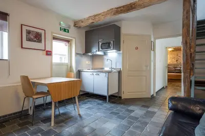 a kitchen with a table and a sink and a counter at Authentic apartment in Voeren in Voeren
