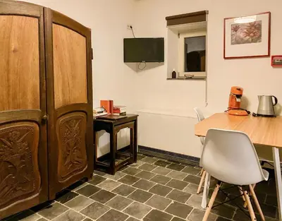 a room with a table and a wooden cabinet at Authentic apartment in Voeren in Voeren