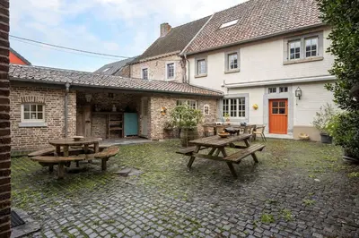 a patio with picnic tables in front of a house at Beautiful appartment in Voeren in Voeren