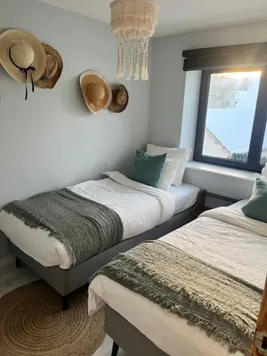 two beds in a room with hats on the wall at De Koer Kanne - bij Maastricht in Kanne
