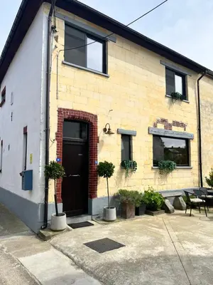 a brick building with a black door and windows at De Koer Kanne - bij Maastricht in Kanne