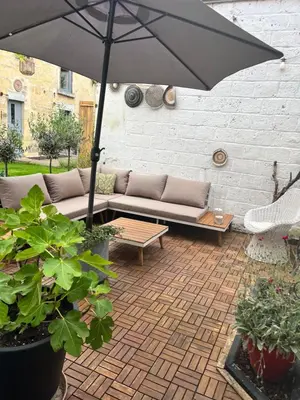 a patio with a couch and an umbrella at De Koer Kanne - bij Maastricht in Kanne