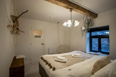 a bedroom with a large bed with towels on it at De Koer Kanne - bij Maastricht in Kanne