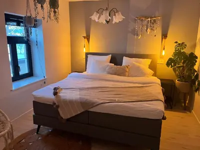 a bedroom with a large bed with white sheets and pillows at De Koer Kanne - bij Maastricht in Kanne