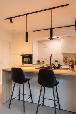 two black chairs sitting at a kitchen counter at NIEUW De Grenspaal NOORD 6P - 3SLPK 5 min Maastricht - SAUNA - LAADPAAL in Riemst