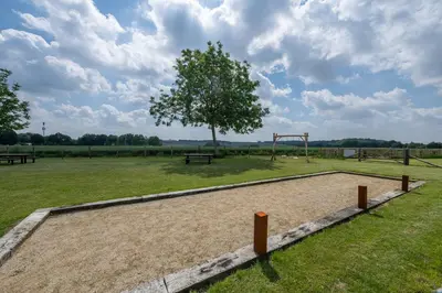 a park with a playground with a tree and benches at NIEUW De Grenspaal NOORD 6P - 3SLPK 5 min Maastricht - SAUNA - LAADPAAL in Riemst