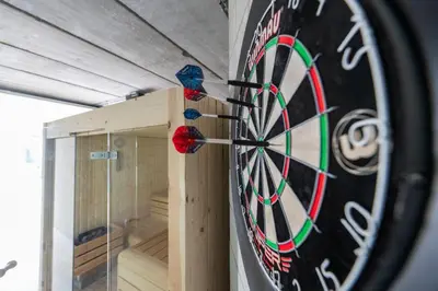 a dart board on the wall of a room at NIEUW De Grenspaal NOORD 6P - 3SLPK 5 min Maastricht - SAUNA - LAADPAAL in Riemst