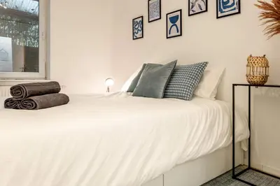 a bedroom with a white bed with pillows on it at Le Quai #7 - Calme et Confort près de Liège in Liège