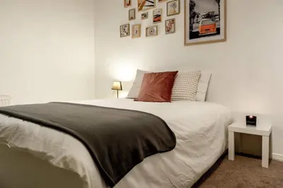 a bedroom with a large white bed and a table at Le Quai #7 - Calme et Confort près de Liège in Liège