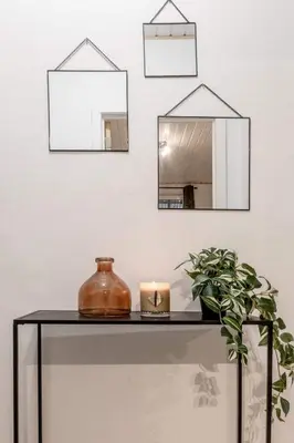 a table with a candle and mirrors on a wall at Le Quai #7 - Calme et Confort près de Liège in Liège