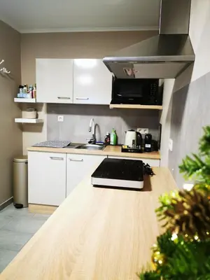 a kitchen with white cabinets and a counter top at Studio Les Champs in Baelen