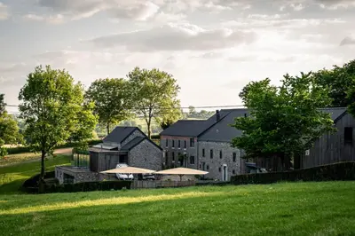 a barn with a grassy field in front of it at Vakantiewoningen Hoeve Carpe Diem - Dalhem - Aubel - Voeren in Dalhem