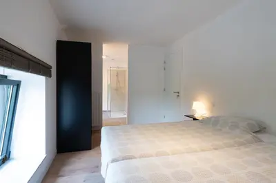 a bedroom with a large bed and a window at Vakantiewoningen Hoeve Carpe Diem - Dalhem - Aubel - Voeren in Dalhem