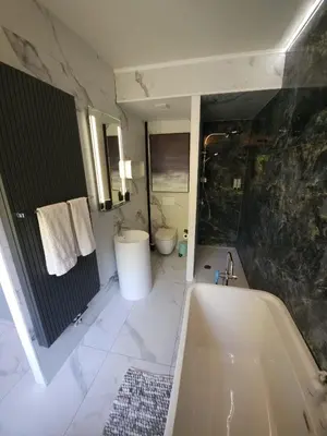 a bathroom with a tub and a toilet and a sink at Lazy Olives in Tongeren