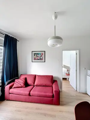 a red couch in a living room with a mirror at Smart Appart - City Center Liege in Liège