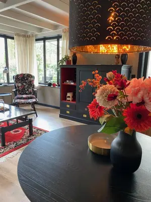 a vase of flowers on a table in a living room at Spechthuisje, 4-pers bungalow in Rekem in Lanaken