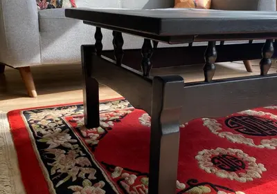 a living room with a table and a rug at Spechthuisje, 4-pers bungalow in Rekem in Lanaken