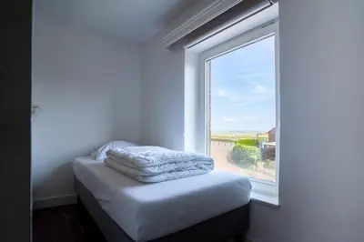 a room with a window with a pile of towels at Maas Suites - The French House in Lanaken
