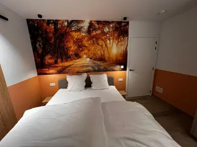 a bedroom with a large painting on the wall at Vakantievilla Eetseveld in Bree