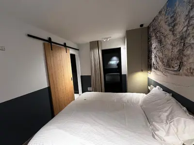 a bedroom with a large bed with white sheets at Vakantievilla Eetseveld in Bree