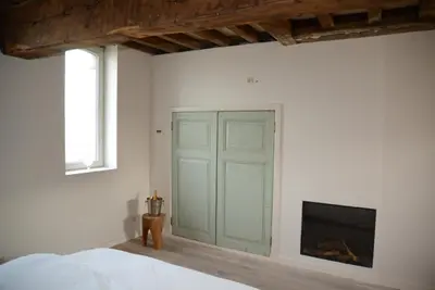 a bedroom with a green door and a tv at Holiday Home Janssen & Janssen in Maasmechelen