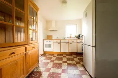 a kitchen with a refrigerator and a checkered floor at Farm Stay Luythoeve in Meeuwen