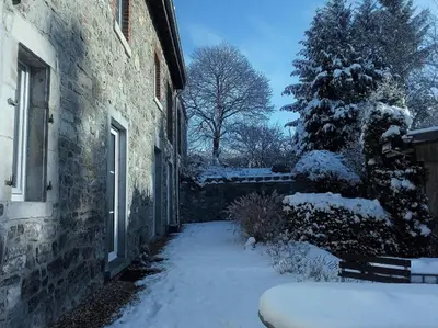 a snow covered sidewalk next to a building with a tree at Point Escale in Lontzen