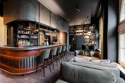 a bar with chairs and a bar counter at Terhills Hotel in Maasmechelen