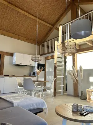 a kitchen and living room with a table and chairs at Chalet Hoge Kempen in Zutendaal