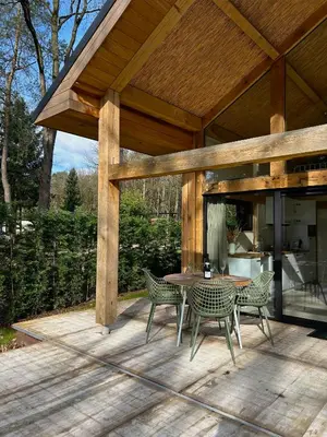 a patio with a table and chairs on a deck at Chalet Hoge Kempen in Zutendaal