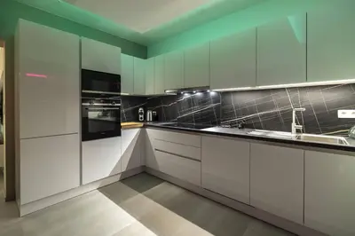 a kitchen with white cabinets and black appliances at SuiteDreams - Bali Suite Liège in Liège