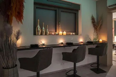 a bar with candles on a counter with chairs at SuiteDreams - Bali Suite Liège in Liège