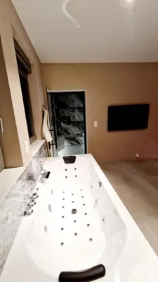 a large white table in a room with a tv at SuiteDreams - Bali Suite Liège in Liège