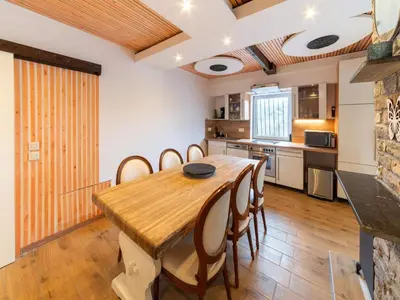 a kitchen and dining room with a wooden table and chairs at Charming Family Home in Esneux in Esneux
