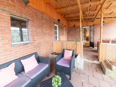 a patio with a couch and chairs on a brick wall at Charming Family Home in Esneux in Esneux
