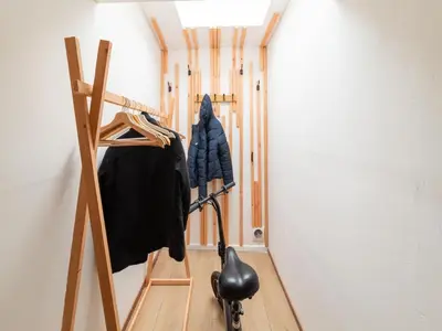a hallway with a coat rack and a black vacuum at Charming Family Home in Esneux in Esneux