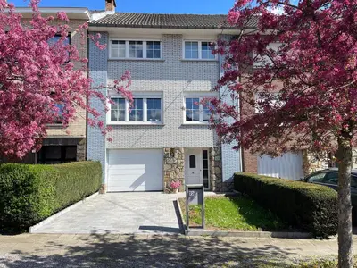 a large brick house with a white garage at Happiness at Lili in Verviers