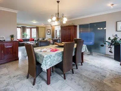 a dining room and living room with a table and chairs at Charming Group Stay in Borgloon in Borgloon