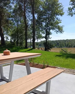 a picnic table with a view of a field at Vakantiewoning Domein Goudveil in Zutendaal