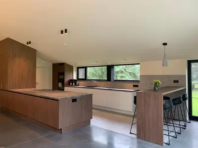 a kitchen with wooden cabinets and a counter top at Vakantiewoning Domein Goudveil in Zutendaal