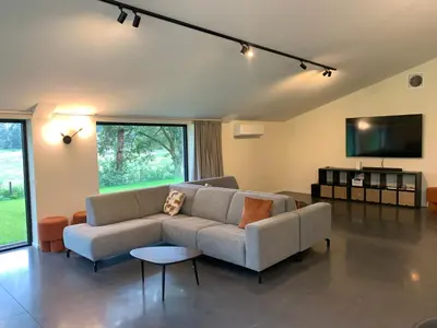 a living room with a couch and a flat screen tv at Vakantiewoning Domein Goudveil in Zutendaal