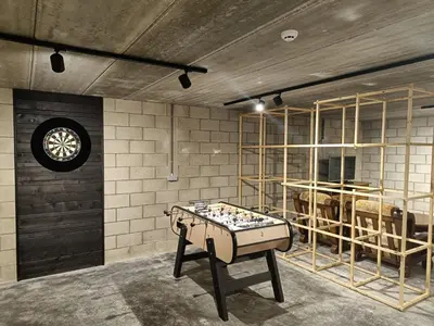 a room with a ping pong table in front of cows at Vakantiewoning Domein Goudveil in Zutendaal