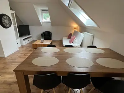 a living room with a wooden table and chairs at Maison Isa in Lommel