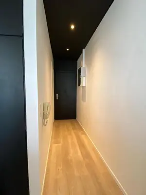 a hallway with white walls and a wooden floor at 